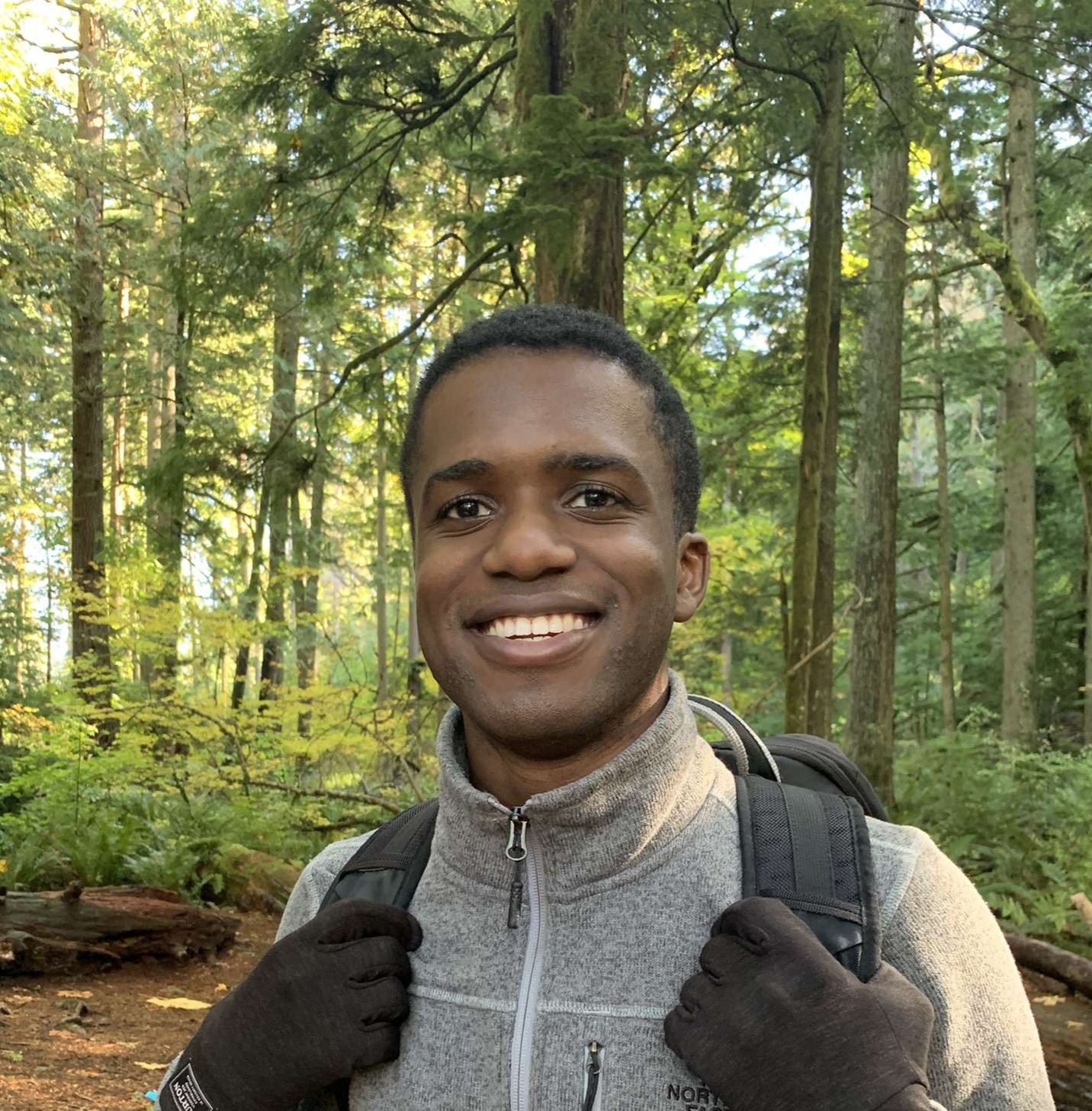 Photo of Hunter in gray sweater with forest trees and foilage in background